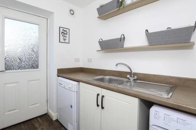 Just off the kitchen is this useful utility room. It has fitted base units with rolled edge worktops, a stainless steel sink with mixer taps and drainer, a built-in cupboard, space and plumbing for a washing machine and space for a tumble dryer. A door leads to the back garden.