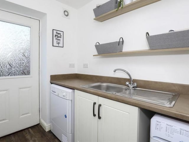 Just off the kitchen is this useful utility room. It has fitted base units with rolled edge worktops, a stainless steel sink with mixer taps and drainer, a built-in cupboard, space and plumbing for a washing machine and space for a tumble dryer. A door leads to the back garden.
