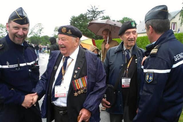 Bill with fellow D-Day veteran Charlie Hill chat to French police officers on a visit to Normandy in 2014