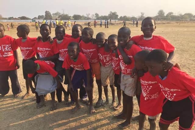 Zambian children coached by Mexborough Life Church wearing T-shirts sponsored by South Yorkshire firms  John Holland and Close Brothers Motor Finance.