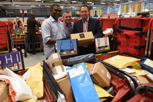 Sheffield Mail Centre worker Nelson Azumah, early shift manager Graham Hammond and manager Mark Owen sort parcels at Brightside Lane