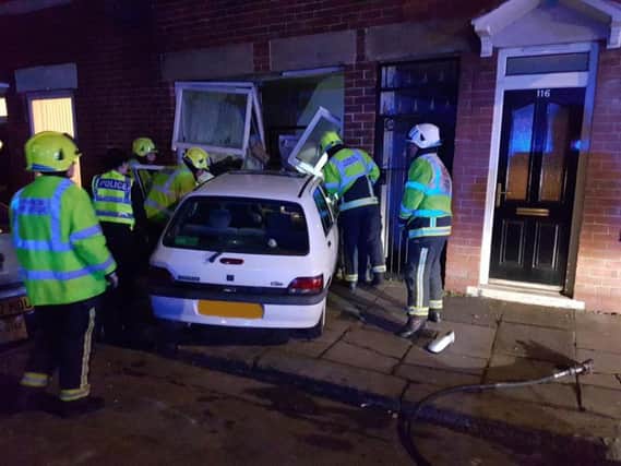 Emergency services attend to the car after it ploughed into the house. Picture: SYP Ops