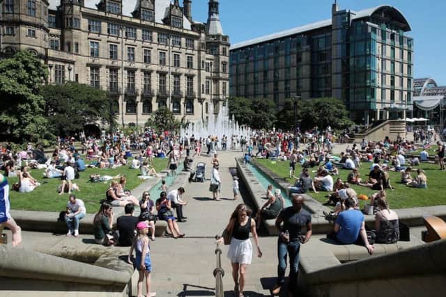 People enjoy the sun in the Peace Gardens on July 19, the hottest day of 2016.