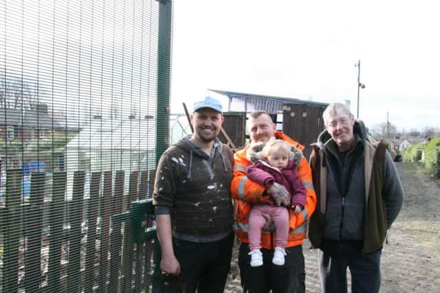 Gardeners beside the new gates installed at Stubbin Allotments