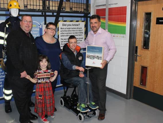 Joe Bowers, from Rotherham, receives an electric wheelchair from HFR Solutions community interest company. Joe is pictured with parents Phil and Tracy, sister Rachel and Ian Marritt from HFR Solutions.