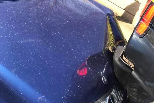 Blue Mercedes after crashing into parked car
