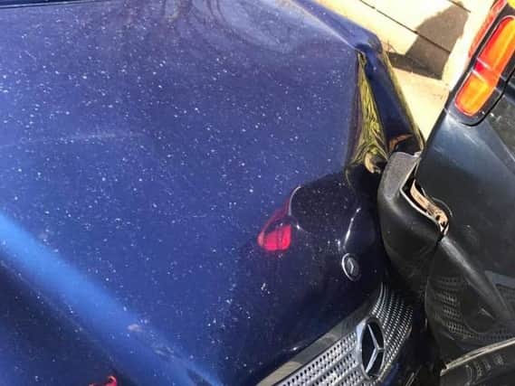 Blue Mercedes after crashing into parked car