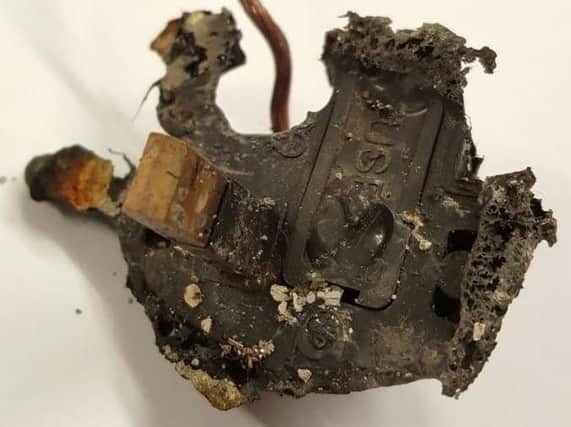 The charred remains of the plug on a faulty heater after a flat fire in Sheffield