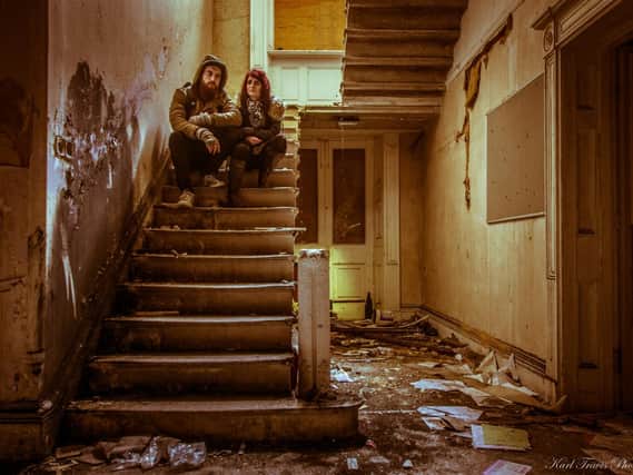 Karl Travis and his partner Kelly Tatler sitting on the stairs of an abandoned nursing school, whose location remains a secret (pi: Karl Travis)