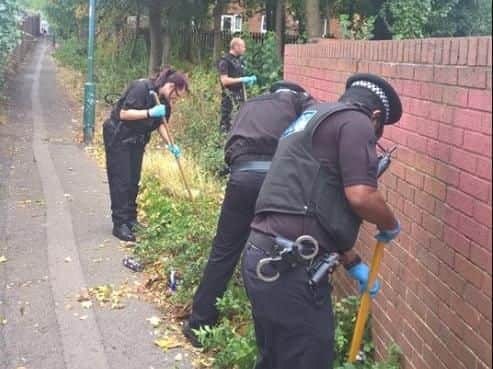 Police officers searching a Sheffield suburb for hidden or discarded weapons