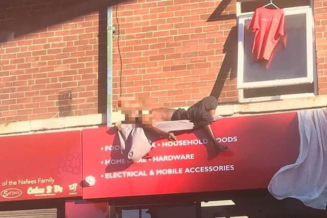 A man has been seen sunbathing on the roof of a Sheffield shop.