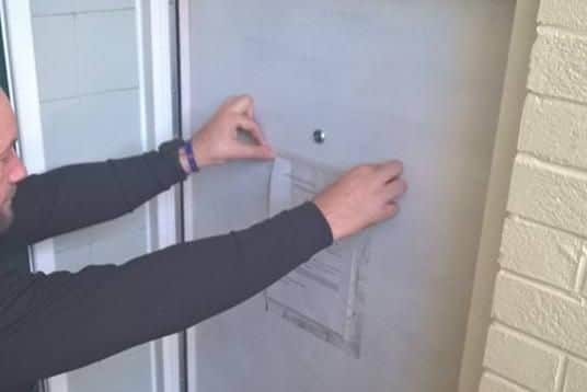 Police pin the terms of the closure order to the door of the property