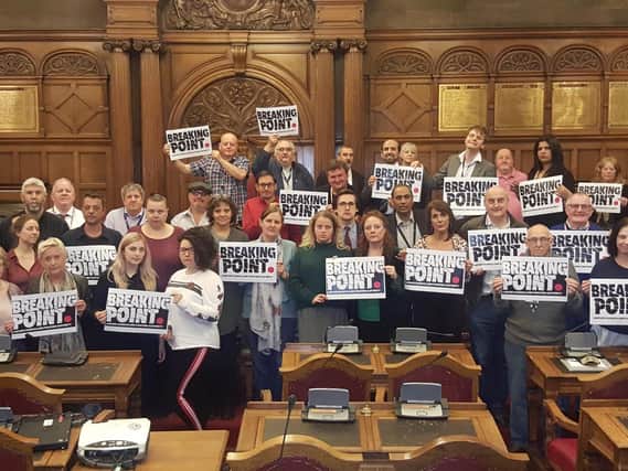 Sheffield Labour councillors holding up 'breaking point' signs in the Town Hall calling for an end to austerity
