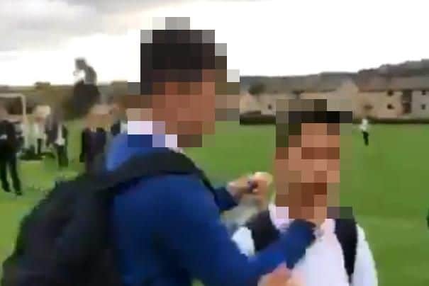 The bully grabs his victim on the school playing fields