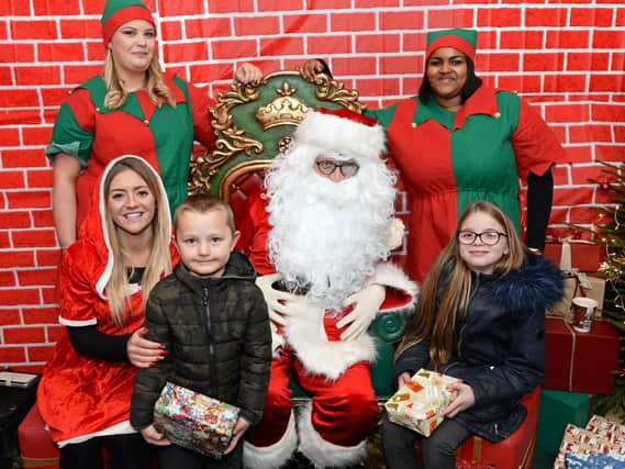 Ant Marketing's Holly-Emma Fordham, Trustee, Mollie May-Fenton, Hannah Chattoo, pictured in Santa's Grotto along with Santa and Harry Jones-Wright, four and his sister Macie, nine.