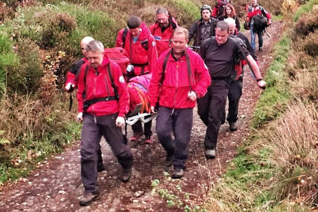 Mountain rescuers carrying a casualty on a stretcher.