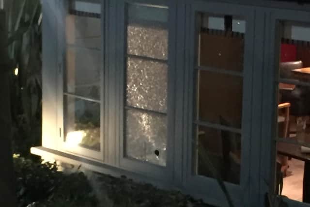 Bullet holes in the window of The Maple Tree pub.