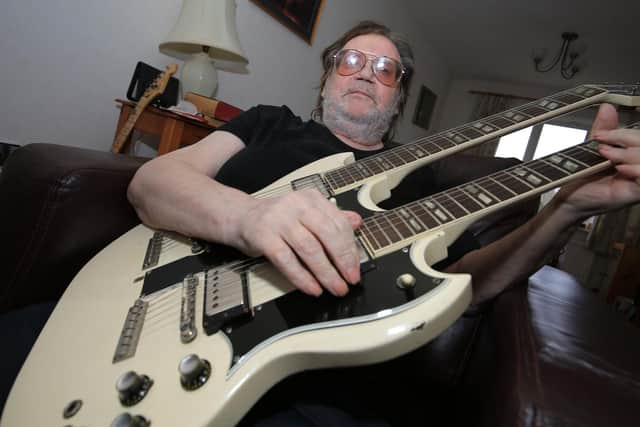 Frank White with his famous 1964 white twin neck Gibson guitar - the first of its model to be shipped from the States. Picture: Chris Etchells