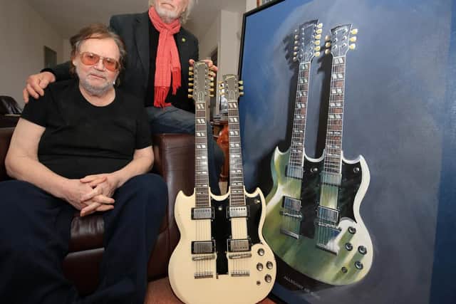 Frank White, and artist Roy Ridsdale, with Frank's famous 1964 white twin neck Gibson guitar - the first of its model to be shipped from the States - and a painting that Roy has done of the instrument. Picture: Chris Etchells