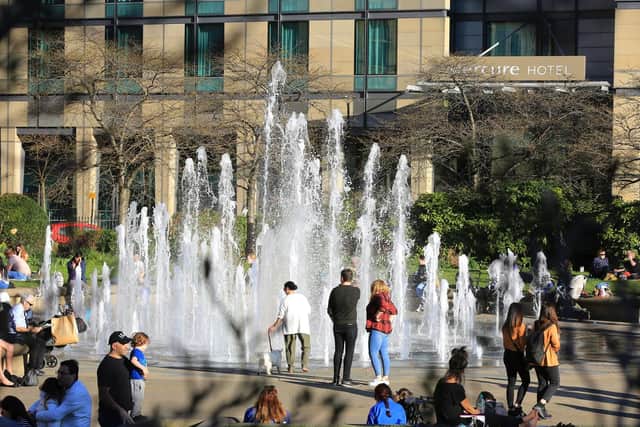 People enjoying the warm February weather at the Peace Gardens in Sheffield city centre