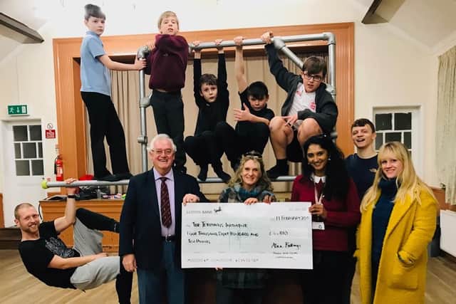 Councillor Bob Pullin with youngsters and the cheque at the Parkour session.