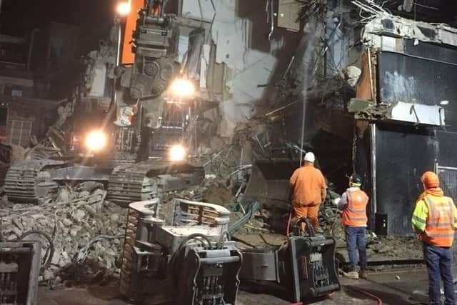 Crews demolish the former Redgates building.