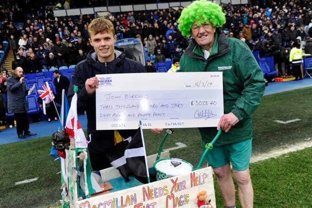 William Hunter hands over his cheque to John Burkhill on the pitch at Hillsborough.
