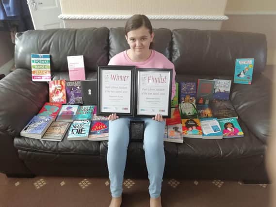 Rhiannon with all the books she won which were signed by the authors themselves
