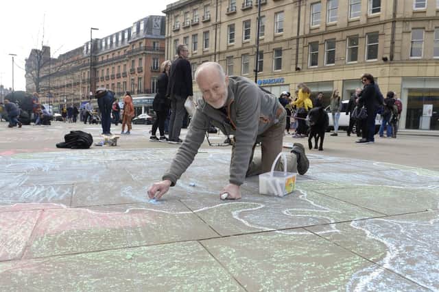 Activists chalking messages outside Sheffield Town Hall to bring attention to climate change