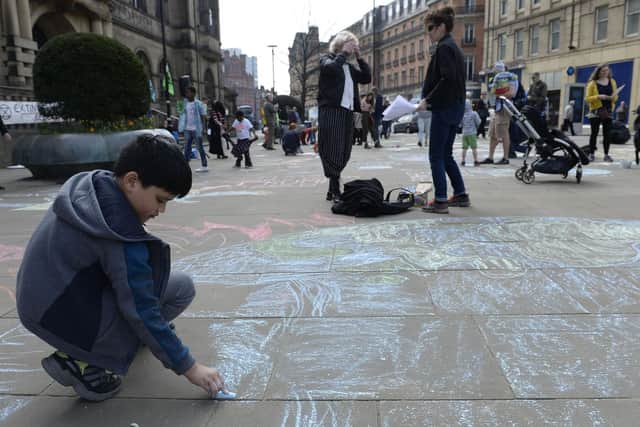 Activists chalk messages pitside Sheffield Town Hall to bring attention to climate change