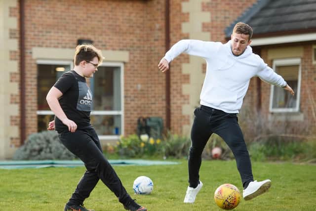 Will Vaulks pictured playing football with Cameron White, 11. Camerons younger brother, Cory, is one of the children currently supported by the hospice. Picture: Ryan Browne/BPI
