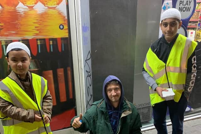 Young volunteers from the As-Salaam Foodbank distribute hot meals to rough sleepers in Sheffield city centre