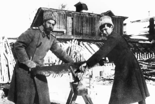Russian Czar Nicholas II, left, and his son Prince Alexei sawing wood to heat the dwelling in Siberia where they were held during the Russian Revolution