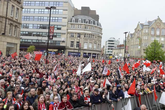 Sheffield United fans celebrate their promotion to the Premier League at Sheffield Town Hall.