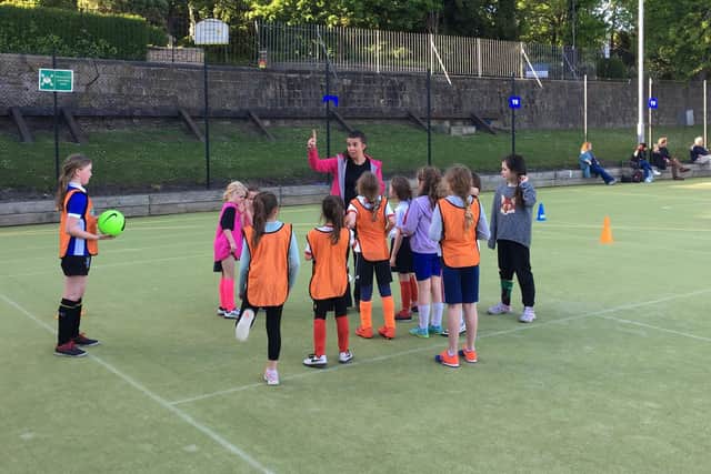 Sam Dyson, coach at Crosspool Juniors Wildcats girls football programme, with some of their young players