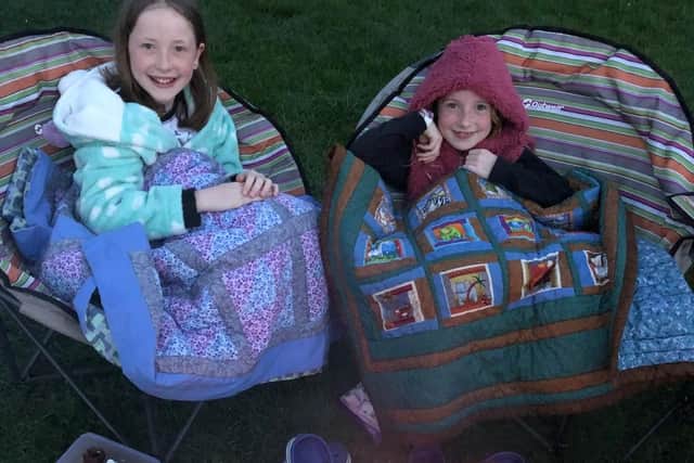 Holly, 11, and eight-year-old Alice with the blankets made by their grandma