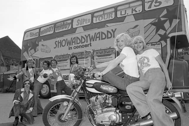 The band touring in style in 1975 with a bus and motorbikes