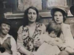 Doris is pictured in the cap, with her mother and her sister on her knee