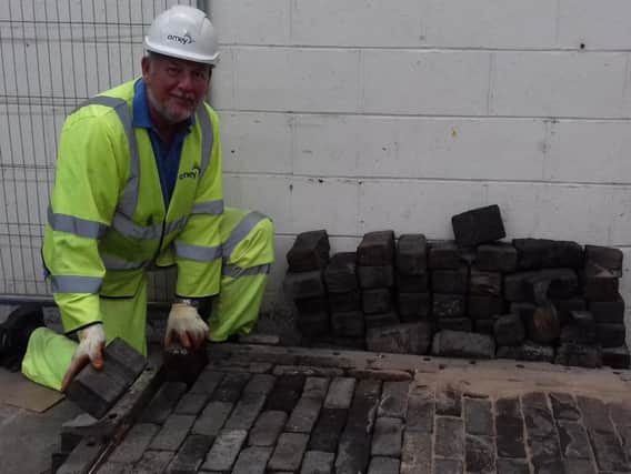 Highways supervisor Gary Booth examines some of the wooden blocks at the Streets Ahead depot in Olive Grove.