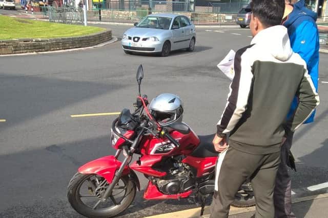 Police stopped this motorcyclist who was giving his friend a lift.