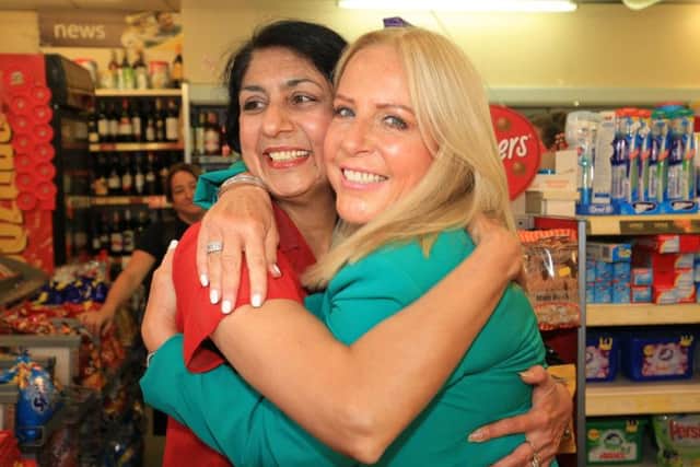 Deana Sampson hugs post mistress Balwinder Dhillon, who sold her the winning ticket all those years ago