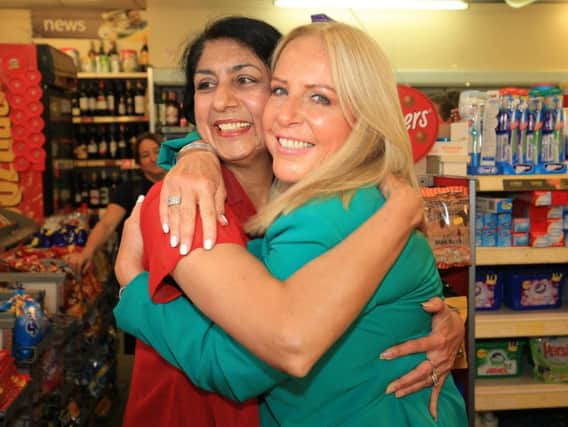 Deana Sampson hugs post mistress Balwinder Dhillon, who sold her the winning ticket all those years ago