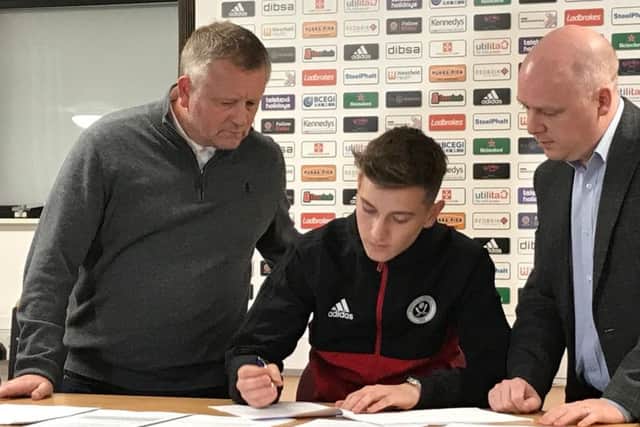 David Brooks, flanked by Chris Wilder (left) and head of football administration Shieber (right) signs a new contract with Sheffield United