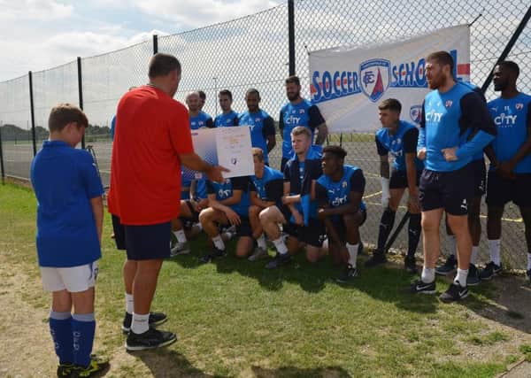 Launch of the Spireires Summer Soccer School at St MaryÃ¢Â¬"s Catholic High School, manager Martin Allen shows players a scrapbook made by fan Joseph Bowmer, 11