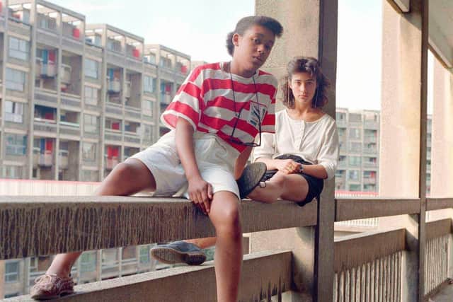 Donna Hargreaves and Carmen Bello sit on an unguarded fourth storey concrete parapet. Hyde Park Flats, Sheffield, 1988, by Bill Stephenson