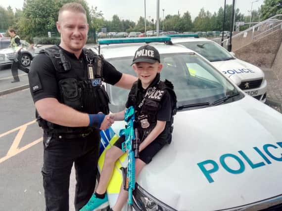 PC Craig Starbuck with Tommy Healy, aged seven, during his tour of Doncaster Police Station.  Picture: David Kessen