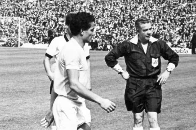 Uruguay Captain, Troche, leaves the field after being sent off by referee Jim Finney, who stands hands on hips to make sure he leaves the field.