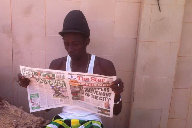 A Gambian man reading the Sheffield Star.