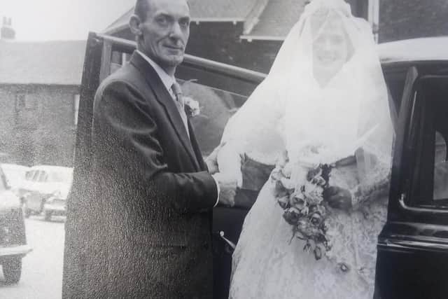 The bride arrives at the church with what appears to be her father.