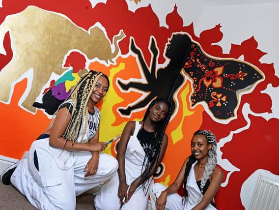 Allia Adam, Julia Hooper and Soha Mohamad with the Hindi inspired mural painted by Allia